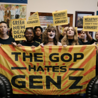 Students stand behind a massive yellow banner saying "The GOP hates Gen Z"