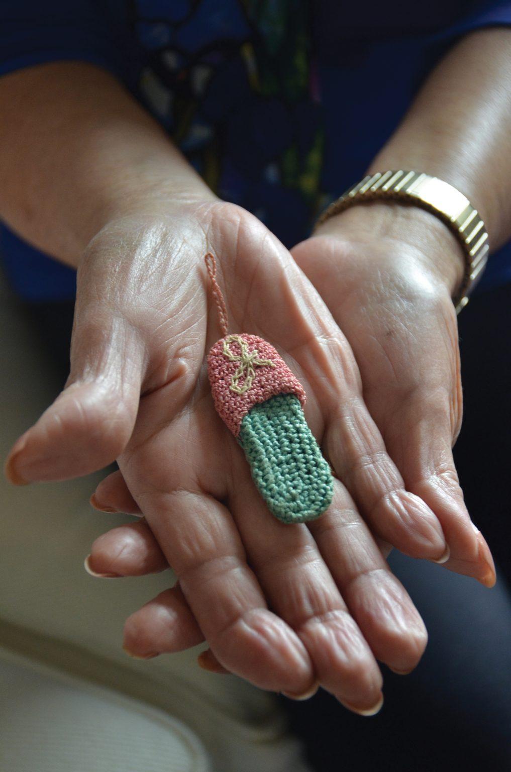 Because there were no means of purchasing accessories in the Internment Camps, Kimoto’s great aunt crocheted this pink and blue slipper for her, which she wore pinned on her blouse. 