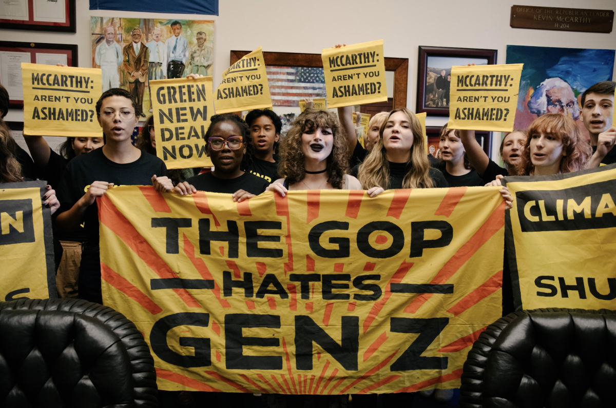 Students stand behind a massive yellow banner saying "The GOP hates Gen Z"