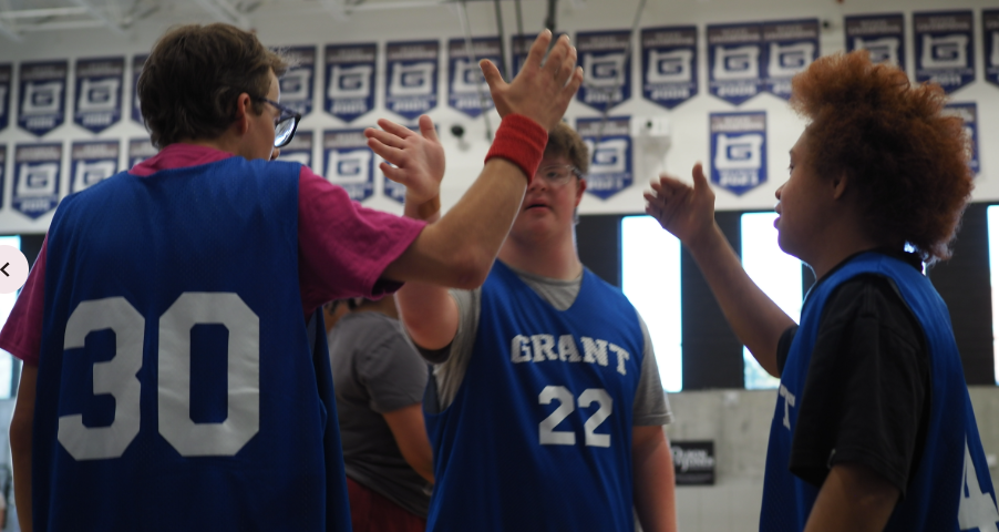 Team Unified Basketball players Robie Rogers (left), Calder Florey (center) and Marciano Stewart (right), cheering each other on in the midst of the game.
